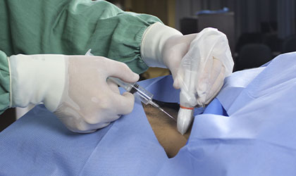 Cirurgião realizando um acesso venoso central no paciente