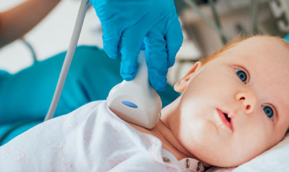 Médico usando o ultrassom para examinar bebê