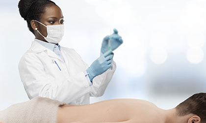 Anestesista verificando injeção antes de aplicar no paciente que está deitado