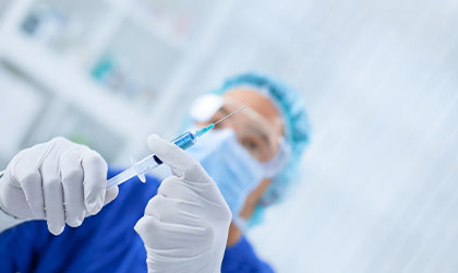 Anestesista verificando a seringa para a aplicação da anestesia