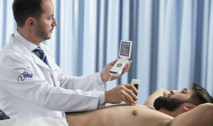 Profissional de saúde realizando ultrassonografia no paciente e vendo o resultado em tempo real
