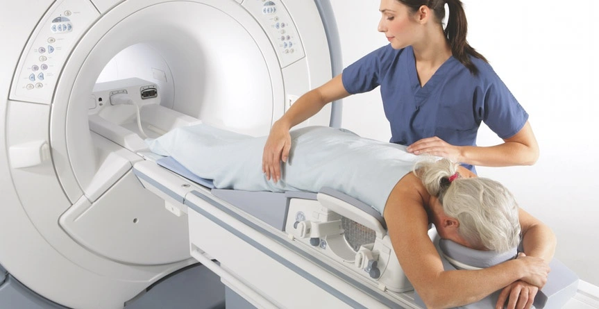 paciente mulher deitada na maca pronta para realizar exame de ressonância magnética