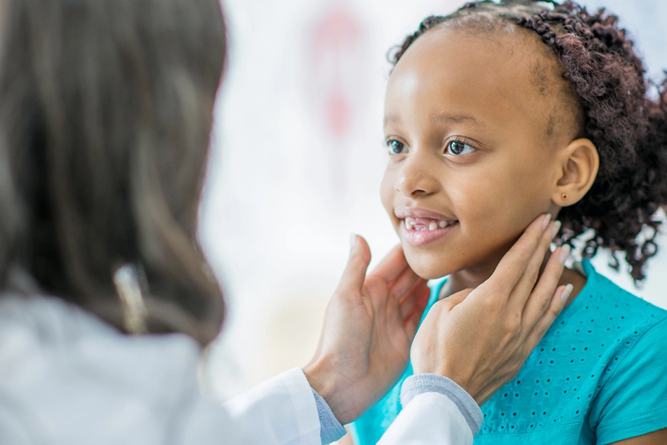 médica examina criança em consulta de Endocrinologia Pediátrica